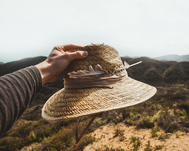 A man holding a straw hat