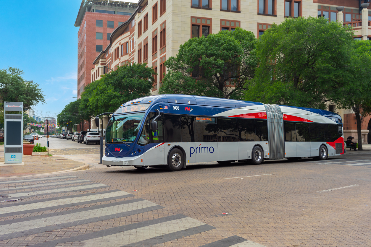 A VIA Metropolitan Transit articulated bus traveling in downtown on Dolorosa Street in San Antonio, Texas