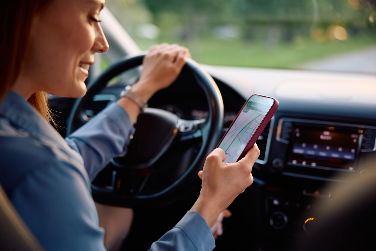 Close up of woman looking for direction on online map while driving car