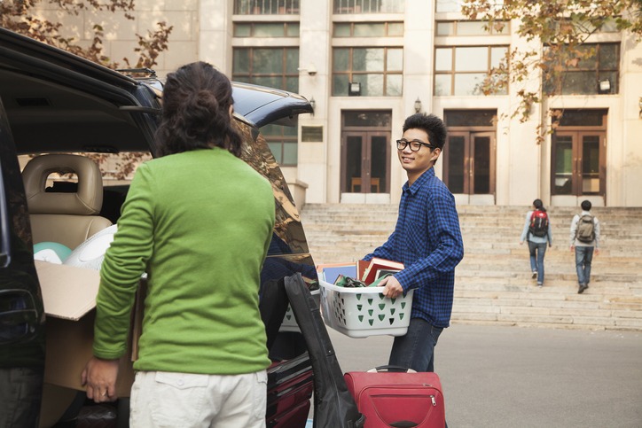 Young man moving into dormitory on college campus