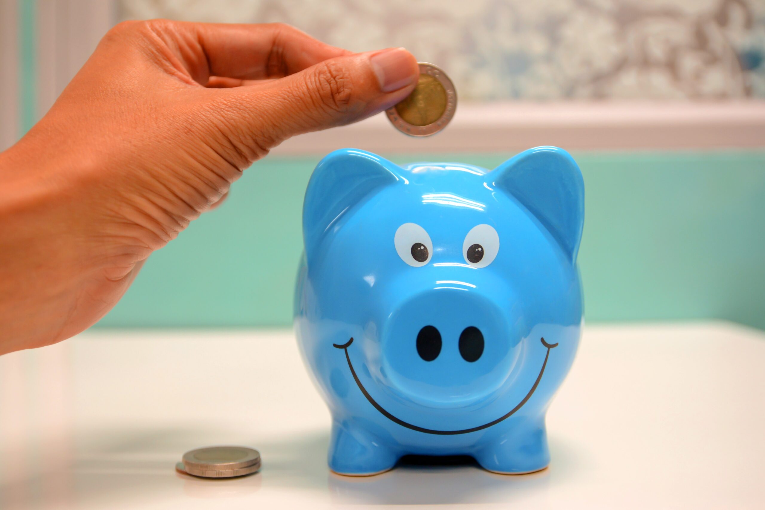 Person-putting-coin-in-a-piggy-bank